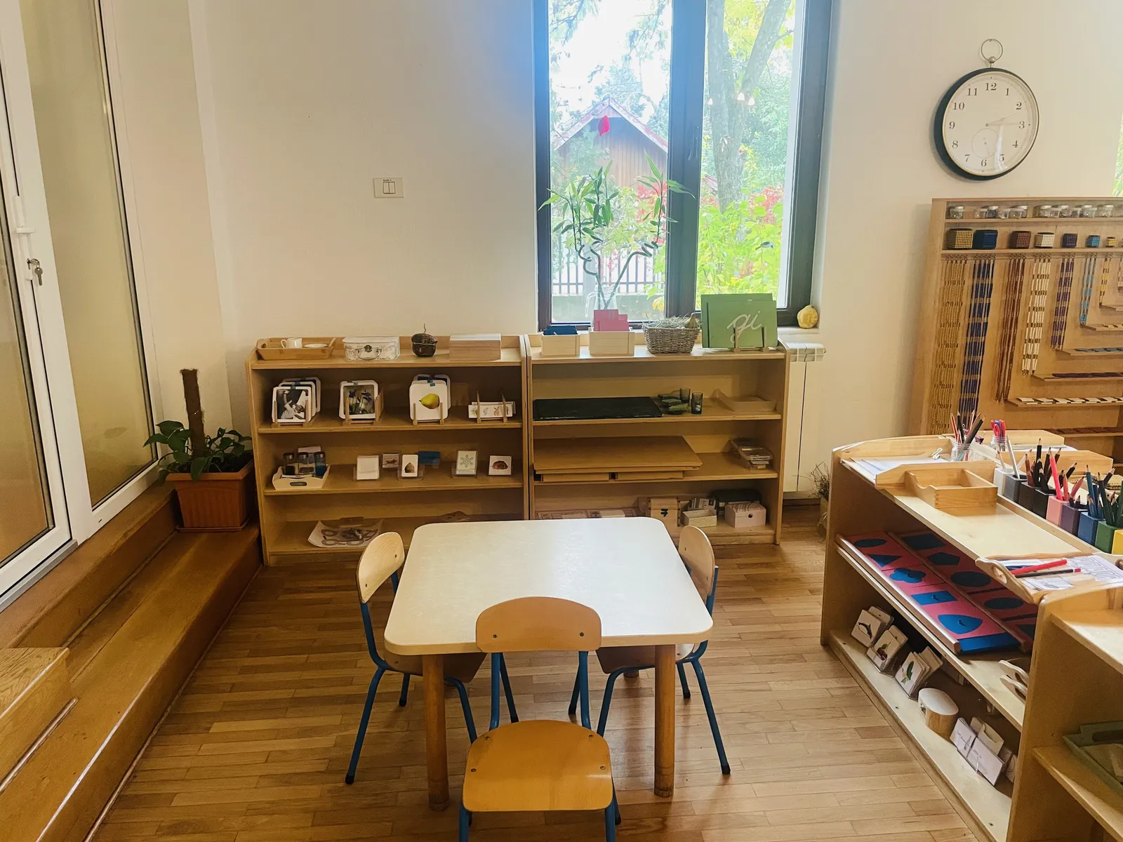 Clasă Montessori în lumină naturală, cu rafturi joase și vedere spre grădină, Arcadia Montessori Corbeanca