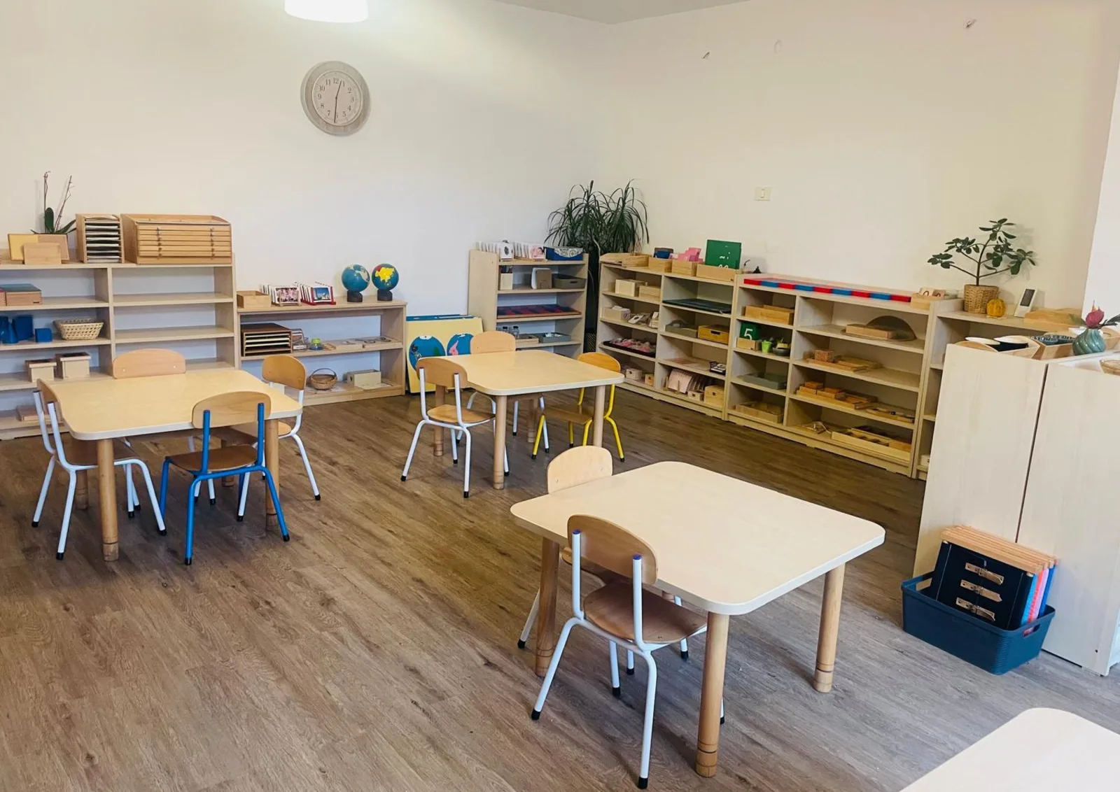 Clasă Montessori luminoasă cu mese, scaune și rafturi pentru Grupa 3-6 ani