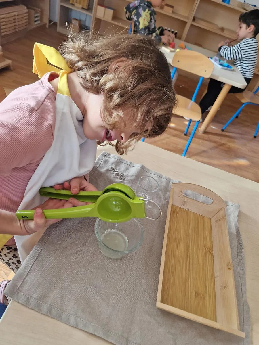 Copilă stoarcând o lămâie la o activitate de viață practică, la Arcadia Montessori
